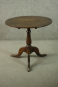 A 19th century tilt top table, with a circular top on a turned baluster stem, with tripod legs. H.66