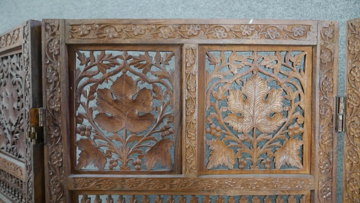 An Indian carved hardwood four fold screen, formed of many panels with carved and pierced leaves and - Image 3 of 8
