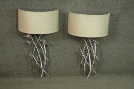 A pair of nickel plated abstract design wall lights by R.V.A. Lighting with cream semicircular