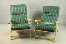 A pair of contemporary teak folding garden chairs, of slatted construction with open arms and