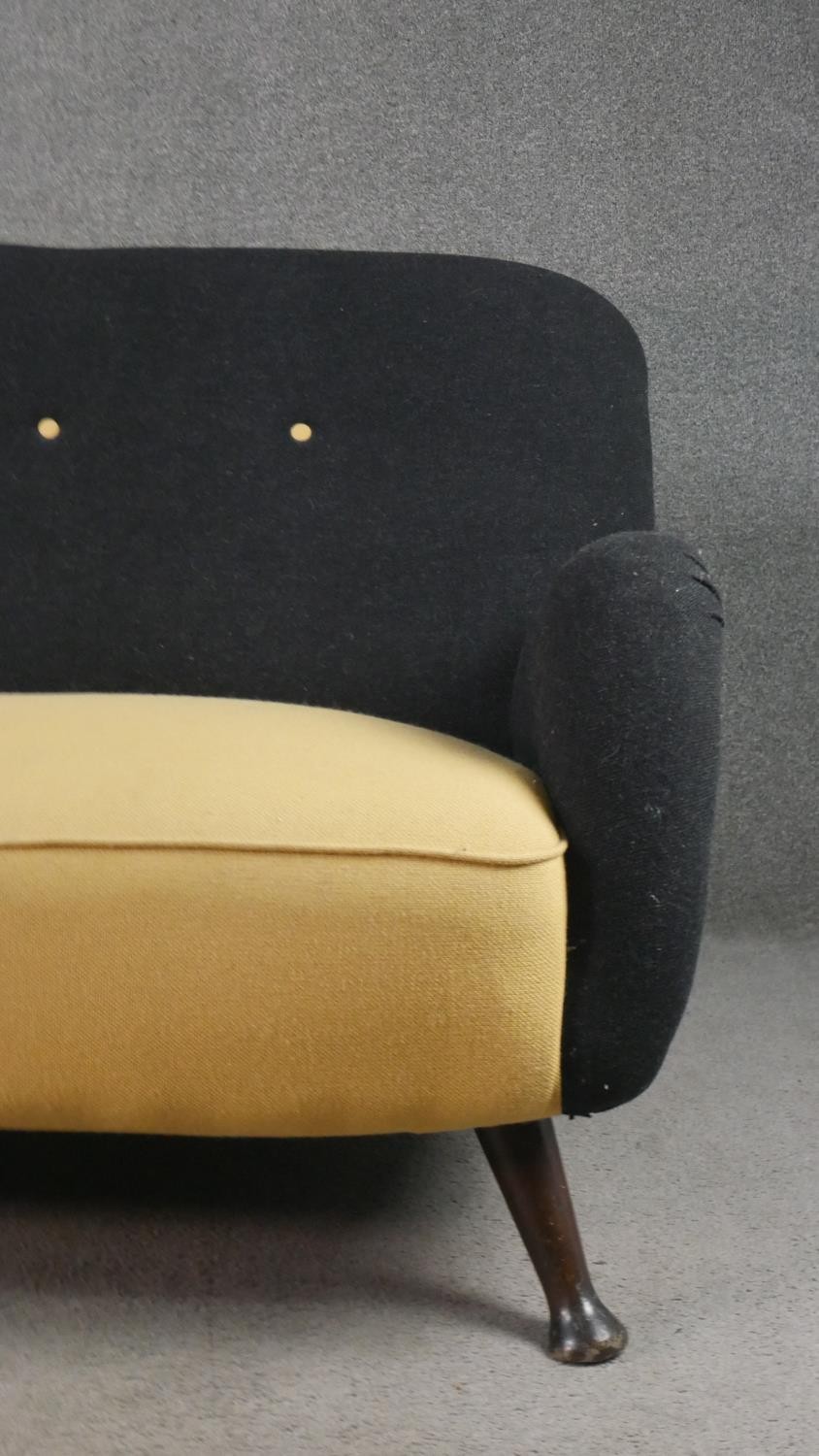 A circa 1950s two seater sofa,, the buttoned back upholstered in black fabric, over a yellow - Image 4 of 6