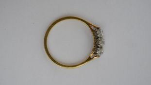 An 18 carat yellow gold and platinum three stone diamond ring, set with three round old cut diamonds