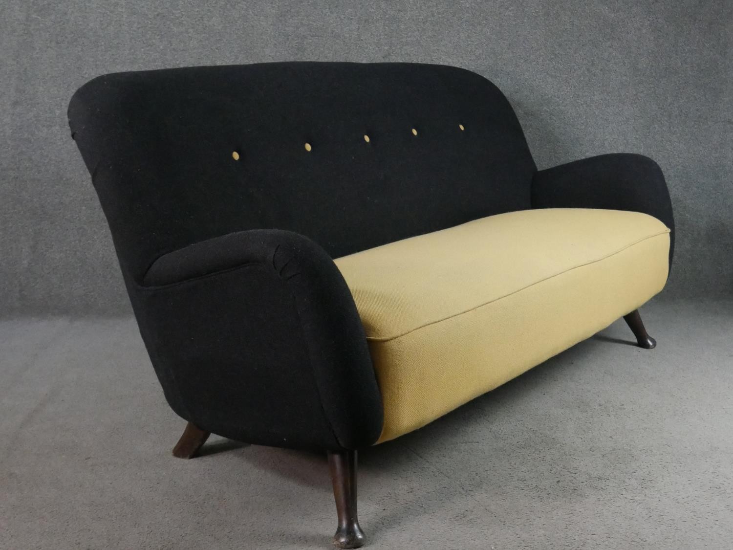 A circa 1950s two seater sofa,, the buttoned back upholstered in black fabric, over a yellow - Image 6 of 6