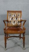A Victorian mahogany library or desk chair, with a buttoned brown leather back, over outswept oven