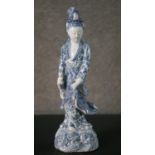 A Kangxi period Chinese hand painted blue and white porcelain figure of a female immortal. She is