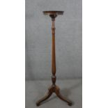 A George III style mahogany torchere, with a circular top on a reeded stem, on tripod supports. H.