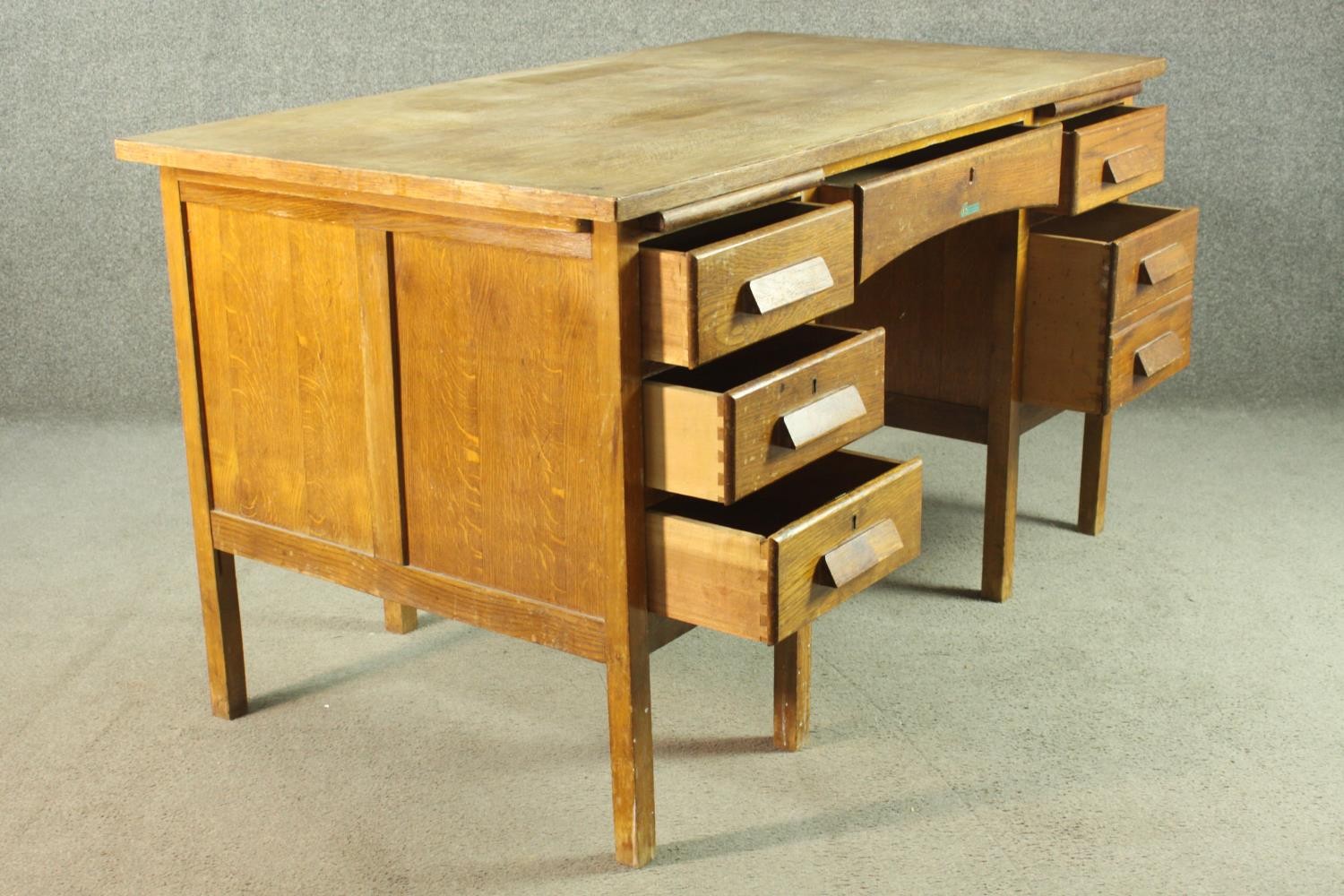 A circa 1940s oak desk, the rectangular top over two slides, and an arrangement of seven drawers - Image 4 of 8