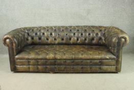 A green leather three seater Chesterfield sofa, with a buttoned back and seat. H.70 W.216 D.85cm.