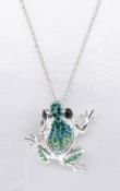 A silver frog pendant set with dark green, pale green and white cubic zirconia's. Black enamel for