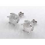 A pair of 14 carat white gold and diamond stylised flower earrings. The two earrings set with a