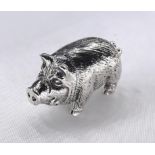 A miniature model of a silver pig with engraved detailing and tusks. Stamped sterling.