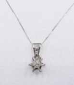 A French Art Deco 9 carat white gold diamond star pendant with 18 carat white gold trace chain.