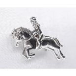 A silver brooch in the form of a horse and female rider. Secure hinged pin to the back with safety