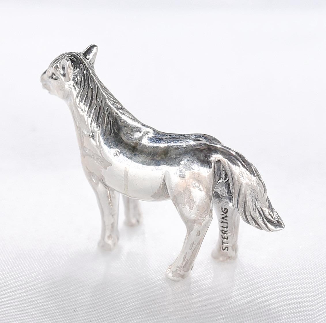 A miniature model of a silver horse with engraved detailing. Stamped sterling. - Image 3 of 4