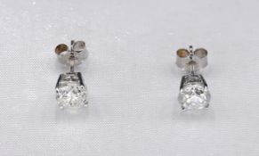 A pair of 14 carat white gold and diamond stud earrings. Each earring set with a round brilliant cut