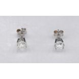 A pair of 14 carat white gold and diamond stud earrings. Each earring set with a round brilliant cut