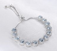 A white metal (tests as silver) cubic zirconia and aquamarine articulated bracelet. Set with