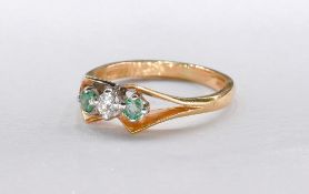 An 18 carat white gold emerald and diamond three stone ring. Set to centre with an oval mixed cut