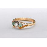 An 18 carat white gold emerald and diamond three stone ring. Set to centre with an oval mixed cut