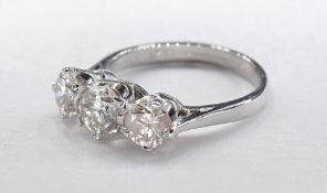 An 18 carat white gold and diamond three stone diamond ring. Set to centre with a round brilliant