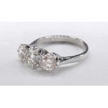 An 18 carat white gold and diamond three stone diamond ring. Set to centre with a round brilliant