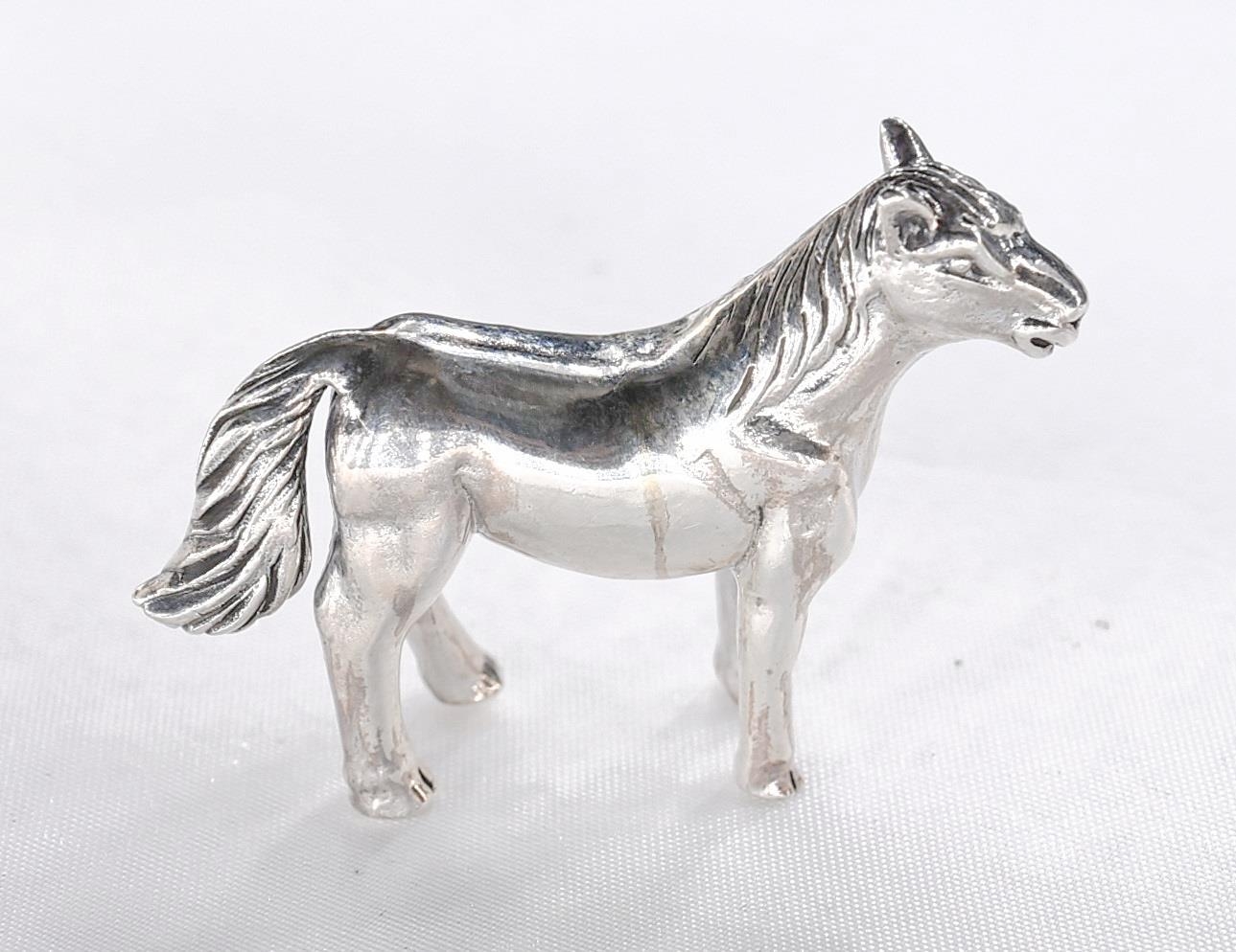 A miniature model of a silver horse with engraved detailing. Stamped sterling. - Image 4 of 4