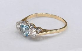 An 18ct yellow gold and white metal aquamarine and diamond three stone ring. Set to centre is a