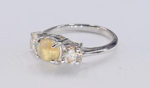 A white metal (tests as white gold) cat's eye chrysoberyl and diamond three stone ring. Set to