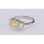 A white metal (tests as white gold) cat's eye chrysoberyl and diamond three stone ring. Set to