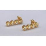 A pair of 18 carat yellow gold and diamond articulated drop earrings. Each earring set with four