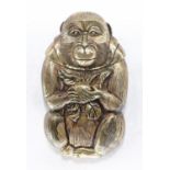 A brass vesta case in the form of a Japanese monkey holding a peach.