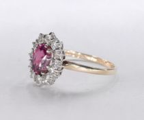 A 14 carat yellow gold pink spinel and diamond cluster ring. Set to centre with an oval mixed cut