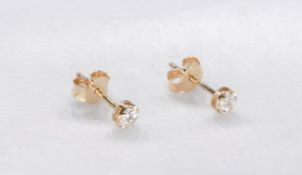 A pair of 9 carat yellow gold and diamond flower stud earrings. The two earrings set with fourteen