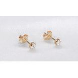 A pair of 9 carat yellow gold and diamond flower stud earrings. The two earrings set with fourteen