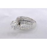 A 14 carat white gold and diamond dress ring. Set to centre with a round brilliant cut diamond in