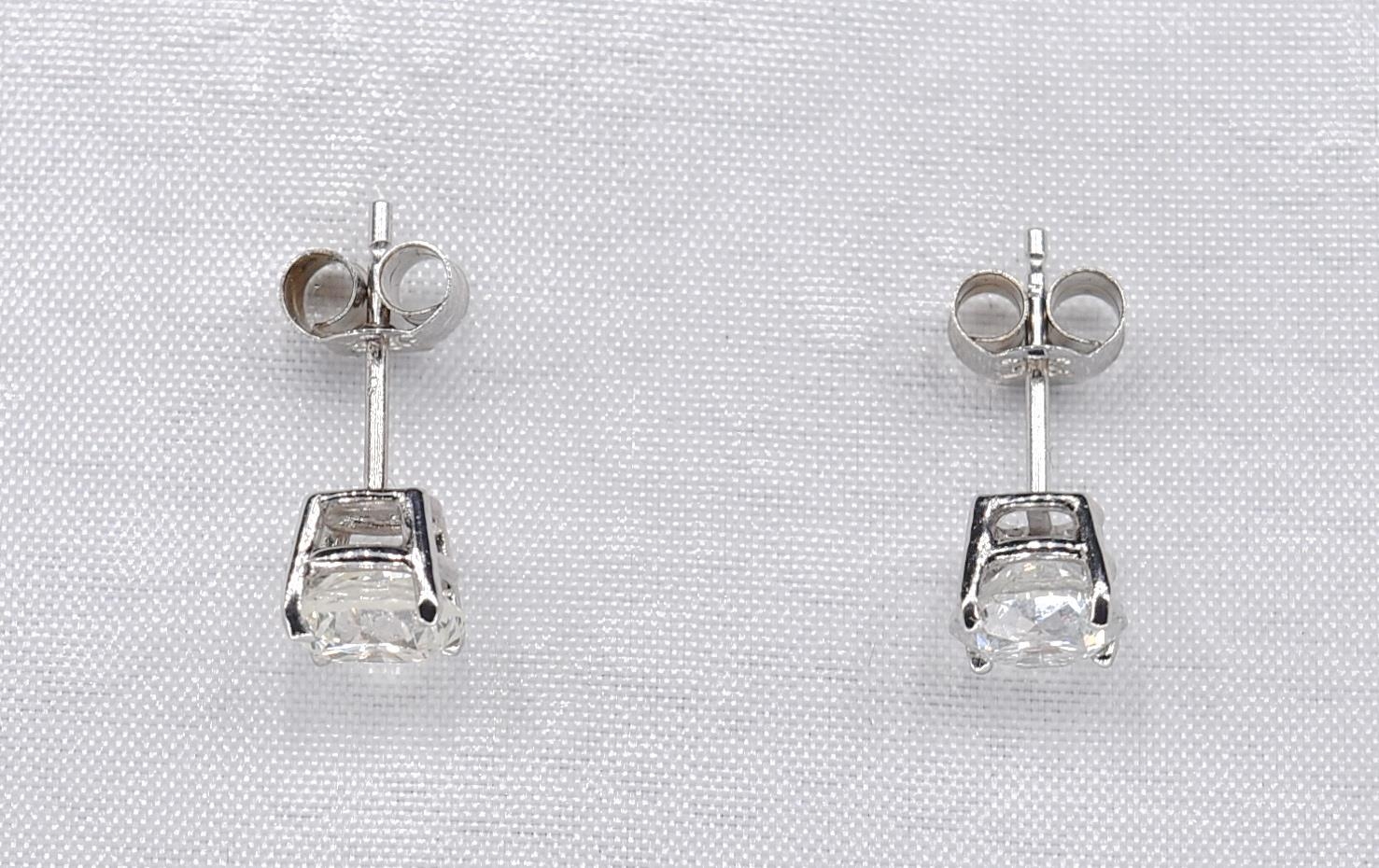 A pair of 14 carat white gold and diamond stud earrings. Each earring set with a round brilliant cut - Image 2 of 3