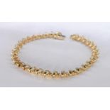 A 14 carat yellow gold and diamond articulated openwork line bracelet. Set with thirty three round