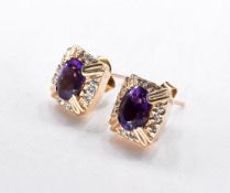 A pair of 14 carat yellow gold amethyst and diamond earrings. Each earring set with an oval mixed