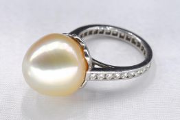 A white metal (tests as 18 carat) yellow South Sea pearl and diamond cocktail ring. Set to centre
