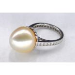 A white metal (tests as 18 carat) yellow South Sea pearl and diamond cocktail ring. Set to centre