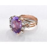 A yellow metal and white metal amethyst and diamond cocktail ring. Set to centre with an oval