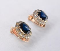 A pair of yellow metal (tests 9ct) cluster sapphire and diamond clip on earrings. Set to centre with