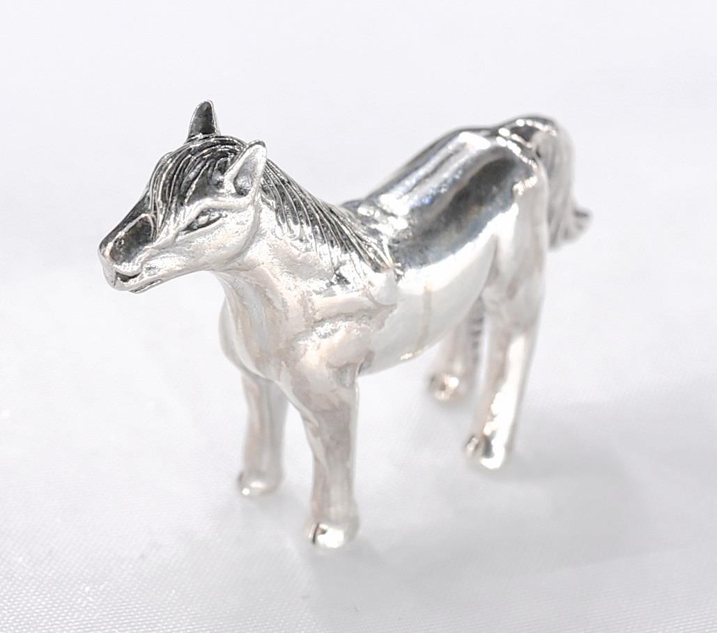 A miniature model of a silver horse with engraved detailing. Stamped sterling. - Image 2 of 4