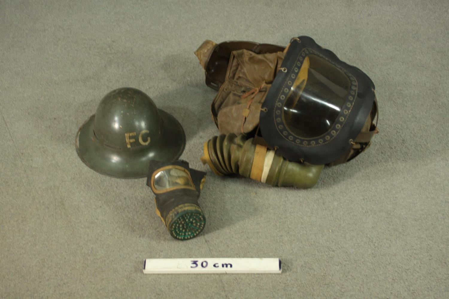 A WWII childs respirator with military issue gas mask and WWII helmet, stamped FG. H47 W.40cm. ( - Image 2 of 9