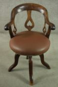 An Edwardian fruitwood swivel desk chair, with a curved back and heart pierced splat, over a