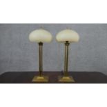 A pair of 20th century brass table lamps, with mushroom form shades, on four reeded columns