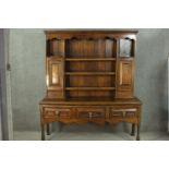 An 18th century country dresser, with three shelves flanked by two panelled cupboard doors and two