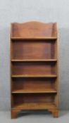 A George III pine waterfall style bookcase, with a shaped top, over four adjustable shelves, on