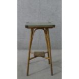 A gold painted Lloyd loom wicker jardiniere stand, with a square glass top, the legs joined by an