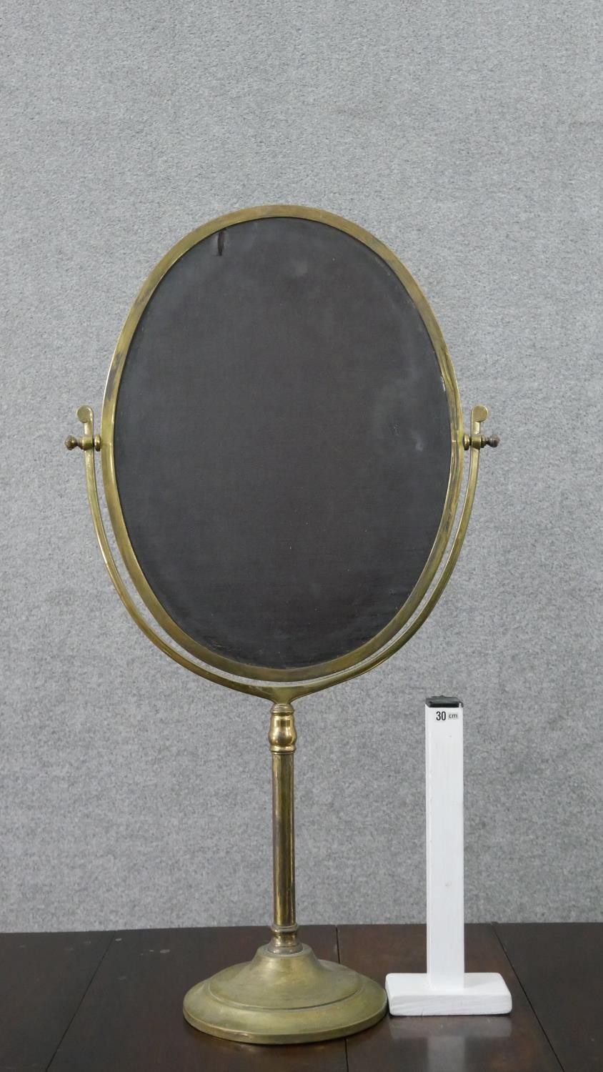 A large 20th century brass swing frame toilet mirror, with an oval mirror plate, on a circular base. - Image 4 of 6